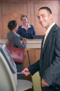 Businessman using ATM in hotel lobby